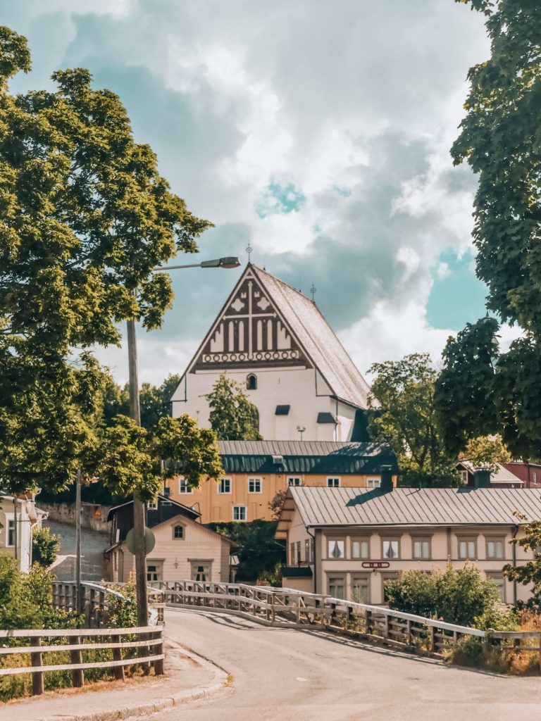 Charming view of Porvoo Old Town with its colorful wooden houses along the river under a bright summer sky.