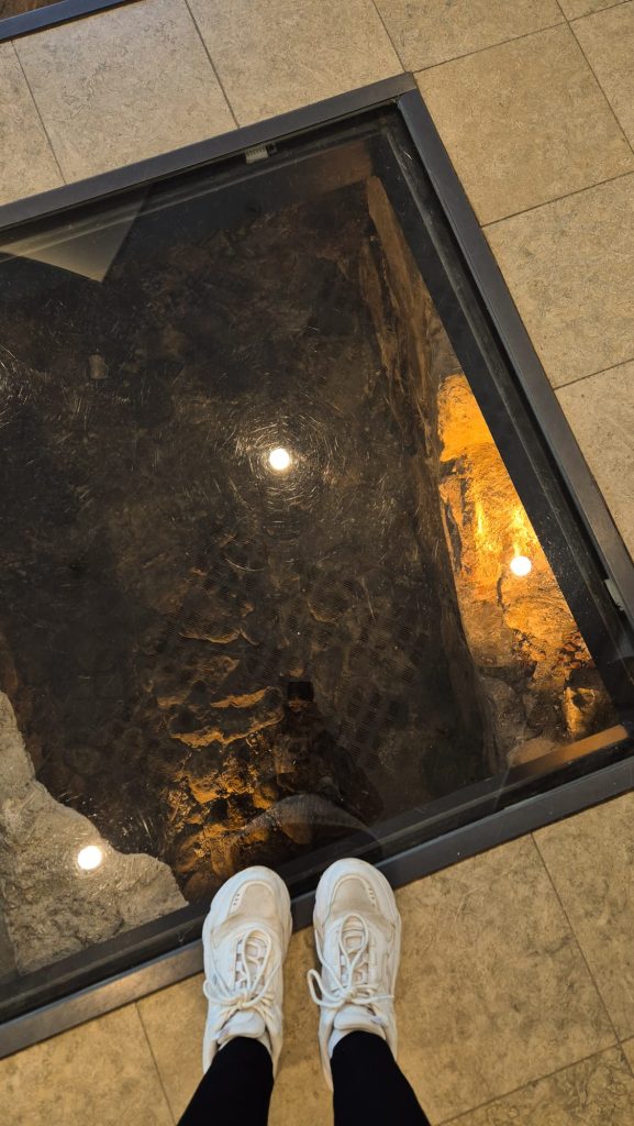 Me standing on the glass floor windows revealing medieval ruins inside Abo Vetus & Ars Nova museum, Turku, Finland.