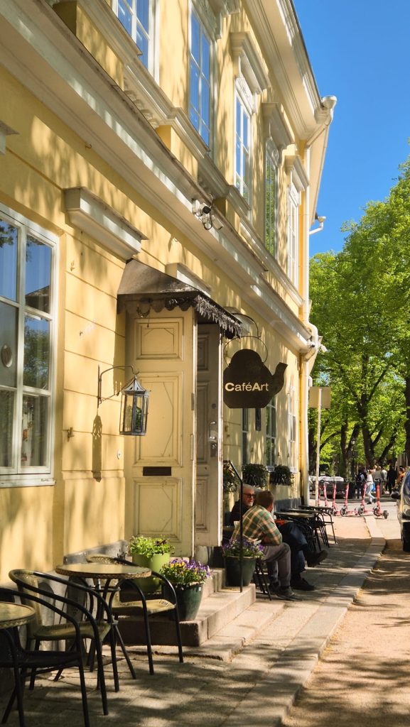 Outdoor seating at Café Art in Turku, Finland with customers relaxing on a sunny summer day.