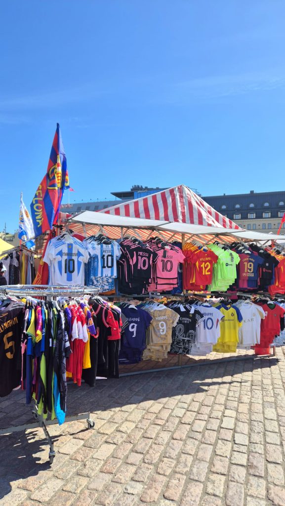 Colorful shirts hanging for sale at Turku Market Square, Finland on a sunny day.