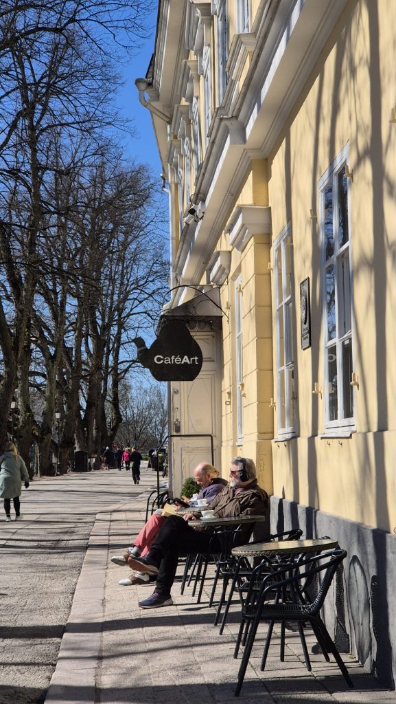 People enjoying coffee outside Café Art in Turku, Finland on a sunny day.