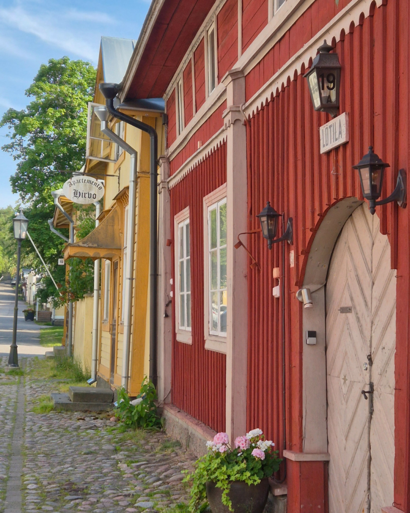 Colourful wooden houses lining a cobblestone street in Old Town Naantali, Finland. 