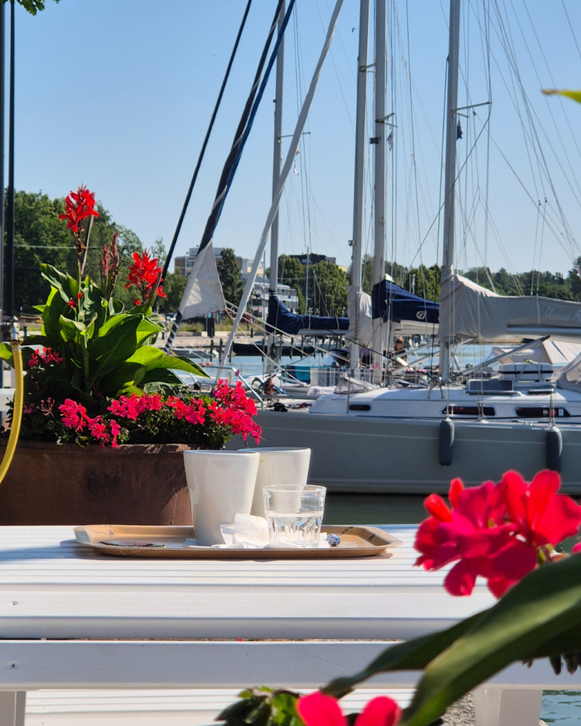 Coffee by the harbour in Uusikaupunki with boats and summer flowers in the background. 
