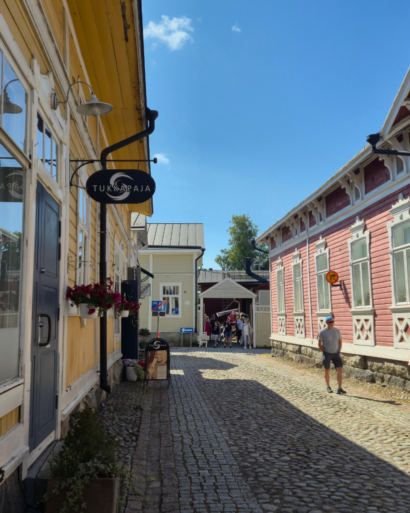 Scenic street in Old Rauma with colourful wooden houses and historic architecture.
