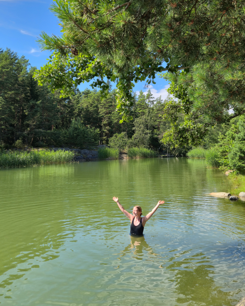 Person swimming in the lake at a Finnish summer cottage.