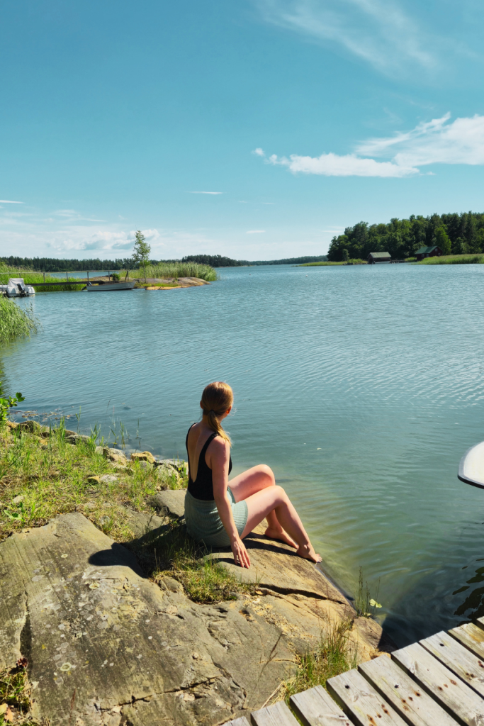 Person sitting quietly and looking out over the sea on a peaceful summer day in Finland.