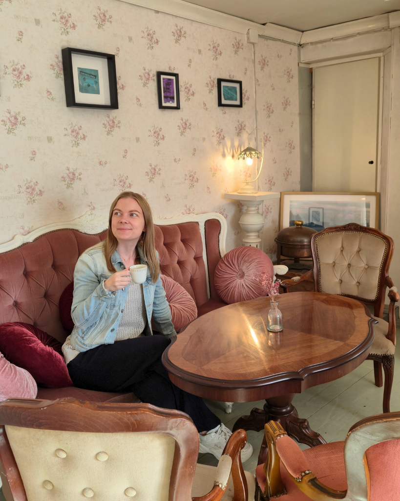 Woman sitting at Café Hallonblad in Parainen, Finland, drinking coffee.