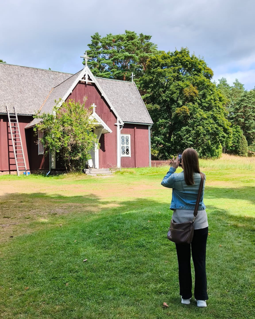 Woman taking a photo of Seili Church on Seili Island in the Finnish Archipelago.