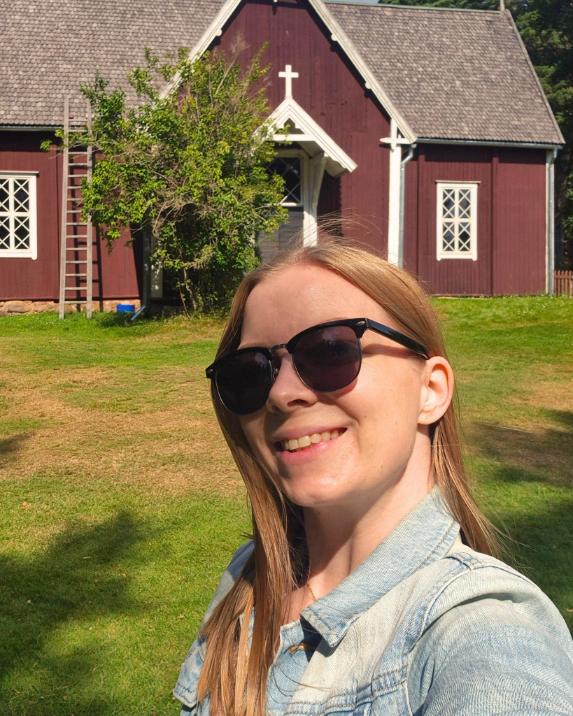 Woman standing outside Seili Church on Seili Island in the Finnish Archipelago.