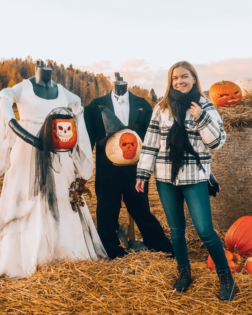 A woman posing with Halloween decorations at Salo Pumpkin Park in Finland during Salo Pumpkin Weeks.