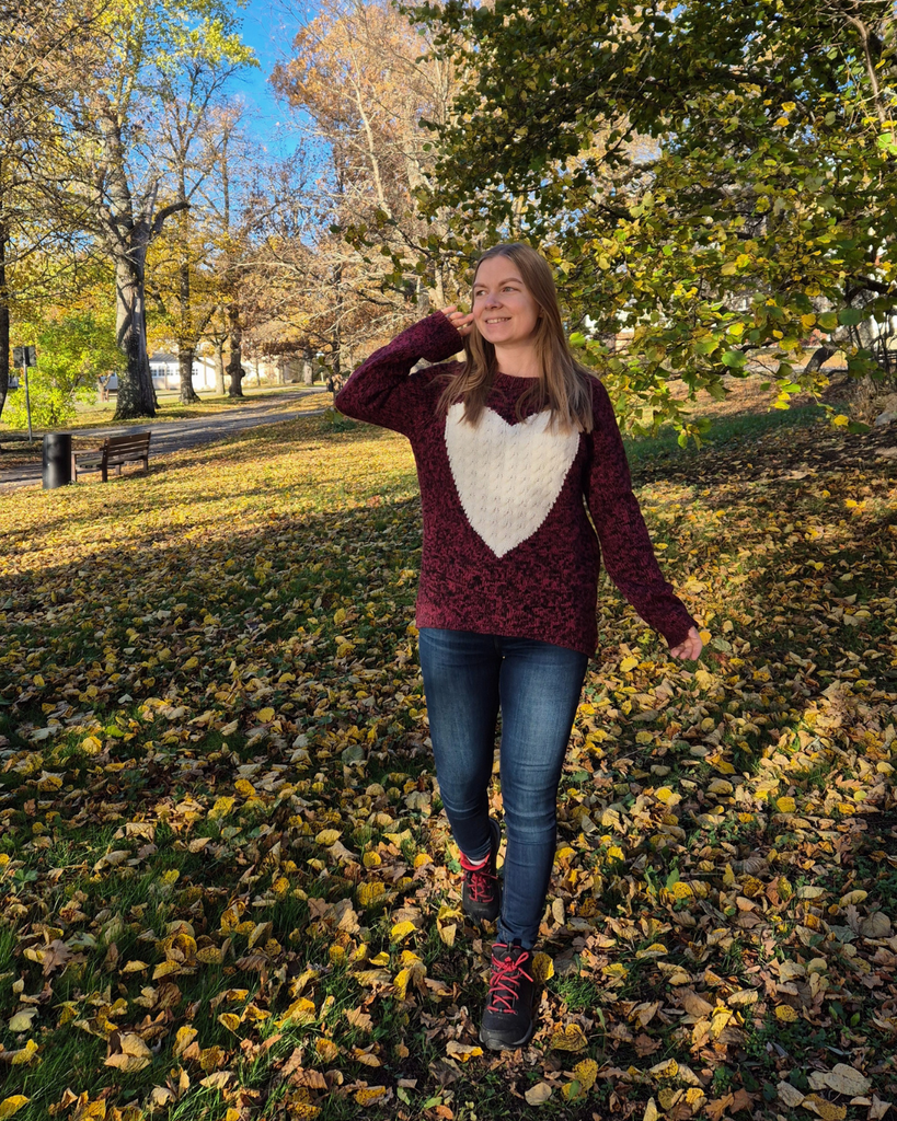 Woman enjoying the vibrant autumn colors in Finland surrounded by trees.