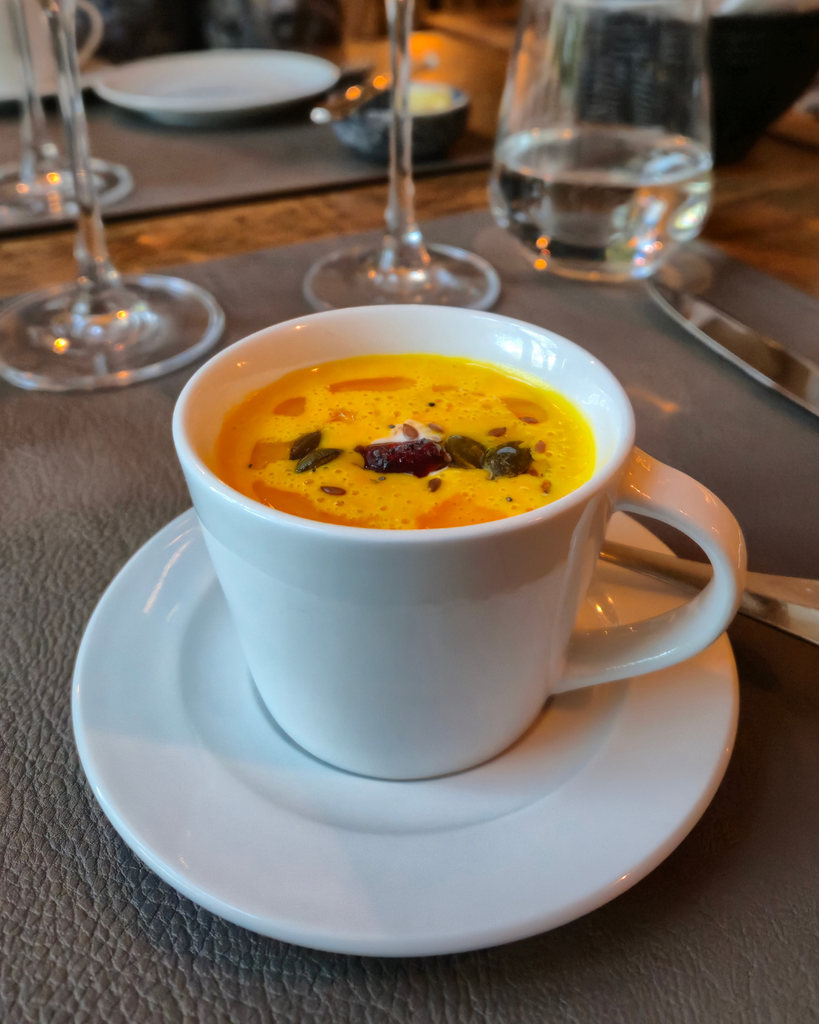 Bowl of creamy pumpkin soup served at a restaurant in Turku, Finland, during autumn.