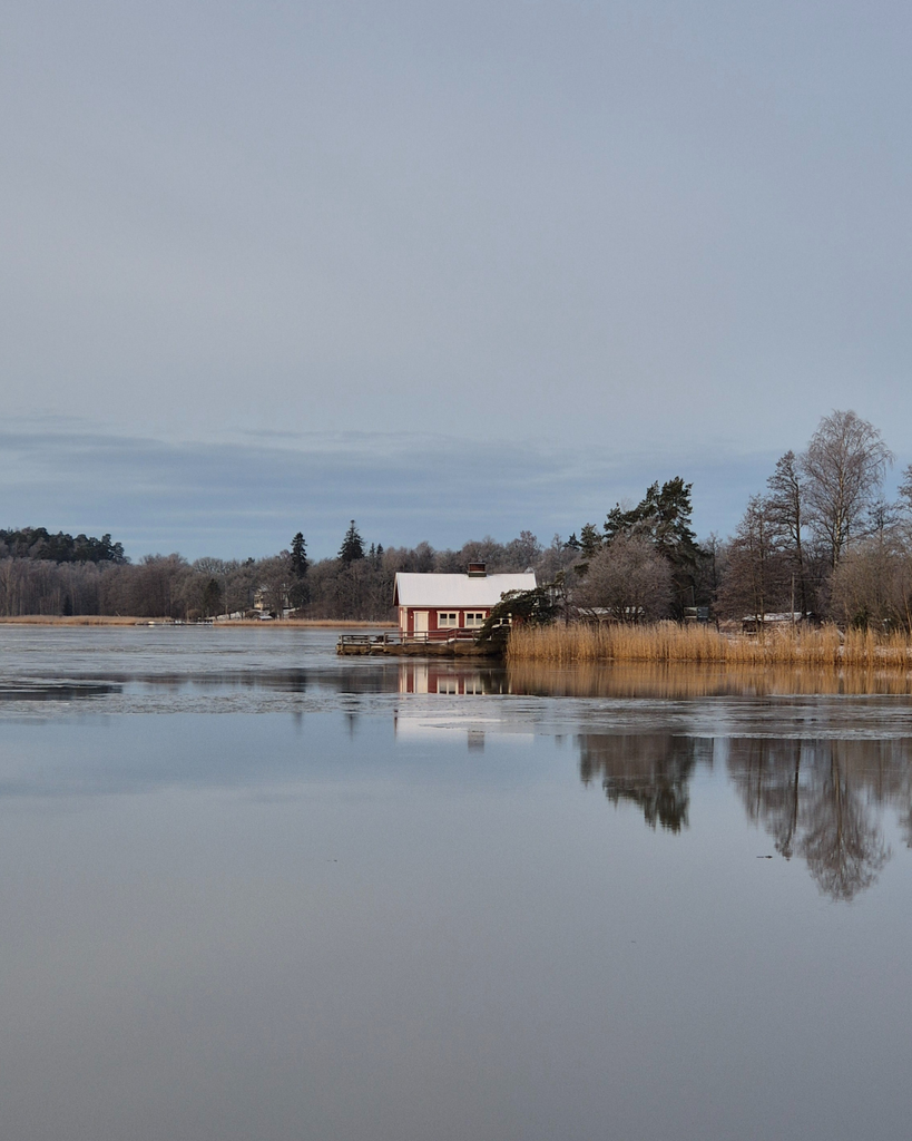 A small seaside cottage overlooking the frozen sea in the Turku Archipelago in winter.