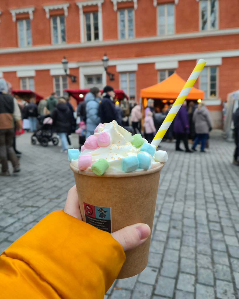 A person holding a cup of hot chocolate at the Turku Christmas Market in Finland.