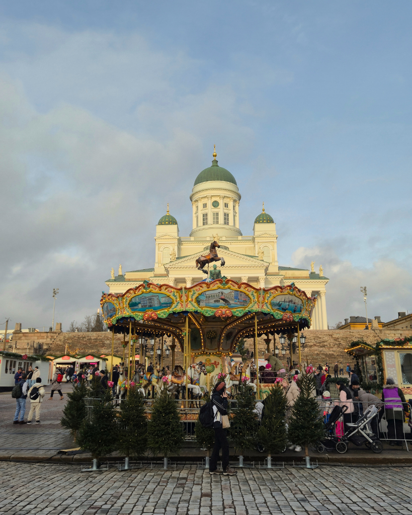 Tuomaan Markkinat Christmas market in Turku, with Turku Cathedral in the background and a carousel in the foreground.