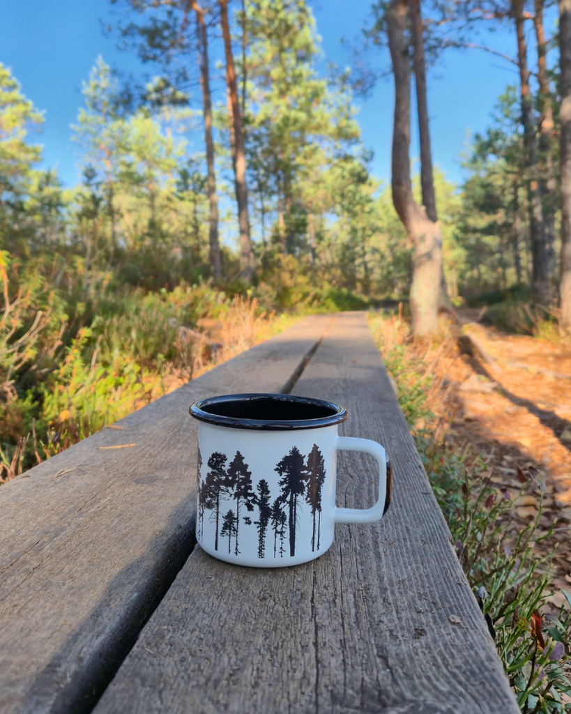 Mug resting beside Savojärvi Lake during a hiking break at Kurjenrahka National Park, Finland.